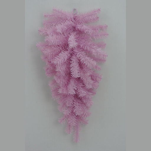 The 24" Pink Artificial Pine Teardrop Swag (82298-PK) features a cluster of pastel pink artificial pine branches elegantly arranged in a downward fan shape, creating a striking teardrop silhouette against a simple gray backdrop—ideal for adding seasonal charm to your decor.