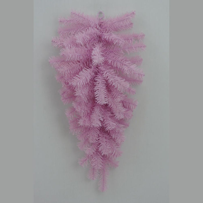The 24" Pink Artificial Pine Teardrop Swag (82298-PK) features a cluster of pastel pink artificial pine branches elegantly arranged in a downward fan shape, creating a striking teardrop silhouette against a simple gray backdrop—ideal for adding seasonal charm to your decor.