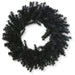 The 24" Black Artificial Pine Wreath 82295-BK features dense, spiky branches in a circular design, ideal for Halloween wreath displays or bringing a touch of gothic décor to your space. Shown against a striking white background.