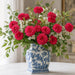 Exclusive Trendy Tree 10 x 10 metal wreath sign featuring a vibrant hot pink zinnia arrangement in a blue and white chinoiserie vase. Floral wreath accent sign. SKU TTE-477.