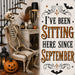 10 x 10 metal Halloween sign featuring a seated skeleton beside a jack-o'-lantern with the phrase "I've Been Sitting Here Since September." Exclusive Trendy Tree Design for deco mesh wreaths, grapevine wreaths, or framing. SKU TTE-512.