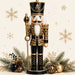 Black and gold Christmas nutcracker with leopard print accents, ornaments, winter greenery and gold snowflakes on metal wreath sign TTE-600.