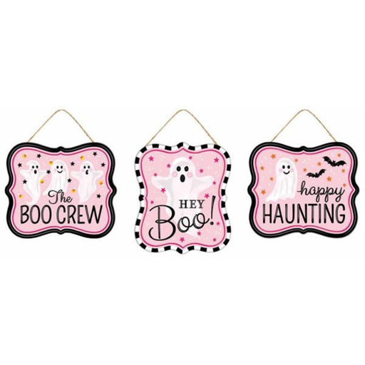 The 3Asst 7Lx6H Tin Matte Ghost Signs Black/White/Pink MD120822 include three cute ghost-themed signs: The Boo Crew (3 ghosts), HEY Boo! (1 ghost), and happy HAUNTING (ghost and bats) on black, white, and pink backgrounds.