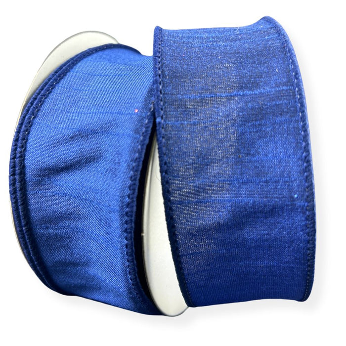 Two rolls of 1.5" Navy Faux Dupioni Wired Ribbon (72434-09-27) lying side by side, each neatly wound around a white spool. These ribbons feature a satin-like texture with a subtle sheen, making them ideal as faux dupioni ribbon for wreath making supplies.