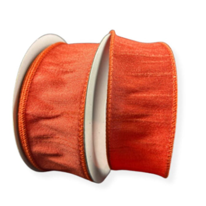 Two rolls of 1.5" Orange Faux Dupioni Wired Ribbon 72434-09-19 with a subtle sheen are displayed upright against a white background. The finished, slightly ruffled wired edges make these ribbons ideal for wreath making and decorative projects.