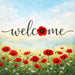 Welcome metal wreath sign with red poppies and wildflowers in a meadow beneath a soft blue sky.