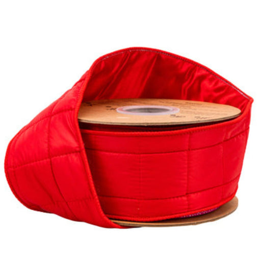 A spool of Wired Red Puffer Coat Ribbon 2.5 Inches x 10 Yards (6510W-250-57E), partially unrolled, reveals a shiny, padded texture reminiscent of winter warmth. Wrapped around a round cardboard core, this ribbon is ideal for Christmas decorating or adding a festive touch to any occasion.