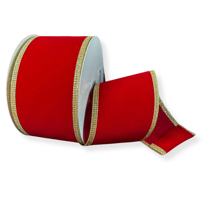 A spool of 2.5" Red Velvet Ribbon with Gold Glitter Edge (76561-40-15) sits on a white background, with part of its luxurious wired ribbon unrolled and lying flat in front—perfect for Christmas decorating.