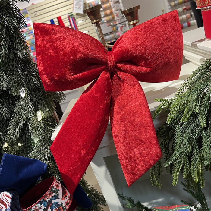 Red velvet 3D hanging Christmas bow measuring 14 by 17 inches with long tails.