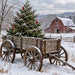 Rustic winter metal sign featuring an antique wooden farm wagon filled with a snowy evergreen tree, three red cardinals, red berries, and a weathered red barn in the snowy countryside, TTE-882.
