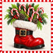 Red Santa boot filled with peppermint candy canes, Christmas greenery, berries, and pinecones