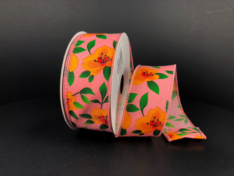 A partially unrolled 1.5X10Y Peach Satin/Orange Magnolias Ribbon (41335-09-23) featuring orange magnolias and green leaves on a dark backdrop beautifully showcases its vibrant floral design.