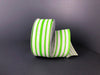 A roll of 1.5X10Y Ivory Green Canvas Stripes 45109-09-09 ribbon is partially unfurled on a dark gray surface, where the vibrant green stripes contrast with the neutral background, adding a lively touch reminiscent of ivory canvas elegance.