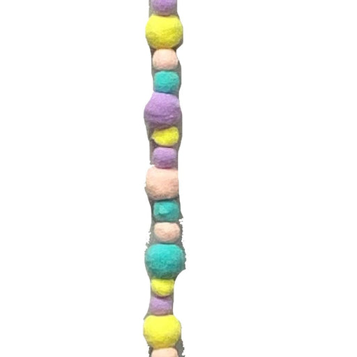 A vertical string of charming, cotton candy-like balls in pastel shades of yellow, purple, pink, and green forms the 4' Pastel Felt Ball Garland 63150PASTEL. The garland is creatively arranged in random patterns against a plain white backdrop.