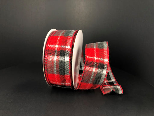 A partially unwound spool of the Brushed Red-White-Green-Black Plaid, 1.5"X10Y Ribbon reveals its checkered design against a dark backdrop.