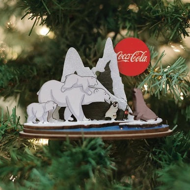 The Polar Bears on Ice CCO115 Old World Christmas Ornament features polar bears, a penguin, and a seal. One bear holds a Coca-Cola bottle with the red logo visible in the snowy backdrop—an ideal addition to your festive collection.