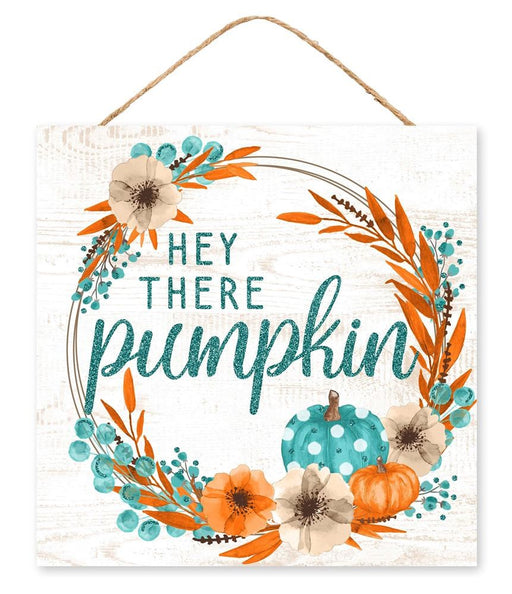 The 10 square Hey There Pumpkin glitter sign (AP8965) in white, teal, orange, and brown features a rustic MDF design with a wood-textured background adorned with subtle pumpkin glitter accents and surrounded by orange and teal leaves, flowers, and pumpkins.