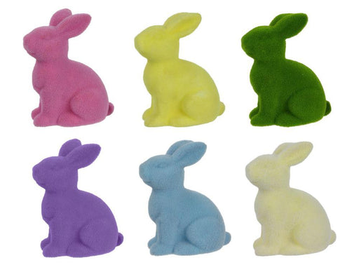 Six 10"H X 8.25"L flocked sitting rabbit figurines, made from polystyrene and nylon in assorted pastel colors—purple, pink, cream, green, blue, and yellow—are arranged in two rows against a plain background.