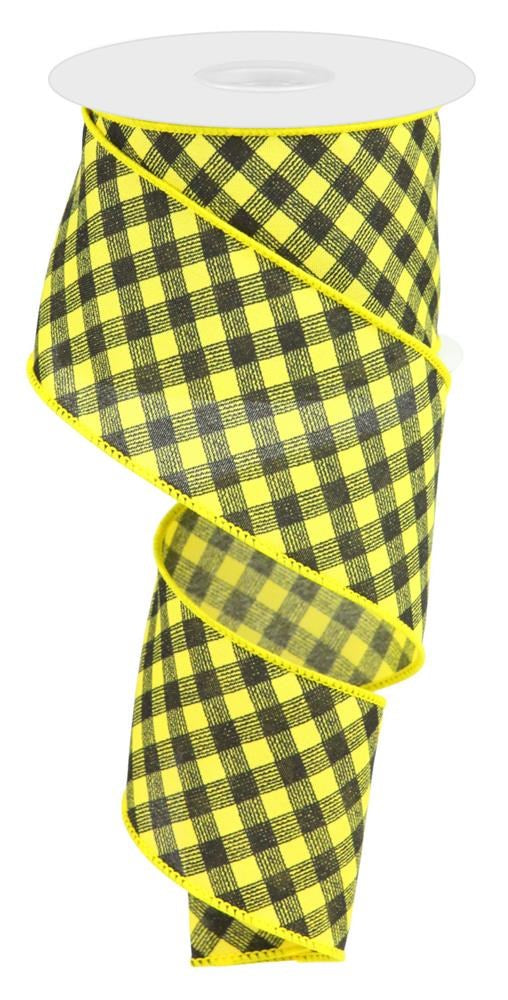 The 2.5X10Yd Bias Gingham Pattern Sun Yellow/Black RGC1331CJ ribbon spirals downward with its matte finish and wired edges, featuring a lively black checkered pattern contrasting against vibrant sun yellow.