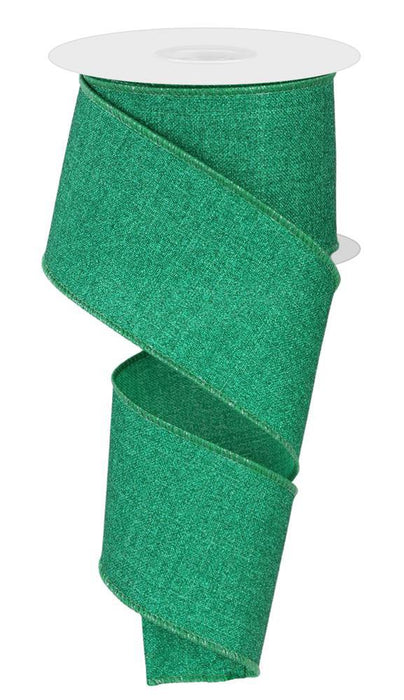 A partially unrolled spool of 2.5X10Yd Fine Glitter On Royal Jadeite ribbon (RGE1381T4) in green, featuring wired edges and a glittery finish.