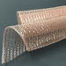 A coiled sheet of 10 Rose Gold Metallic Foil Poly Mesh XB90510-34 features a grid-like pattern against a dark background, with its shiny, reflective surface exuding a warm metallic hue.
