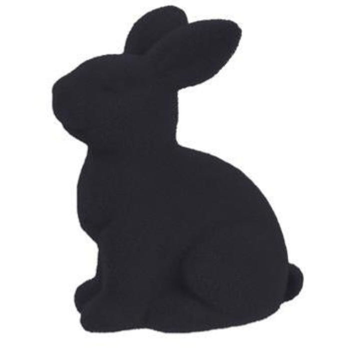 A 10H x 8.25L flocked sitting rabbit crafted from polystyrene/nylon, featuring a smooth black velvet texture, is upright with perked ears facing left against a plain white background. Part of the HE723199 series available in assorted colors: purple, pink, black, green, orange, and turquoise.