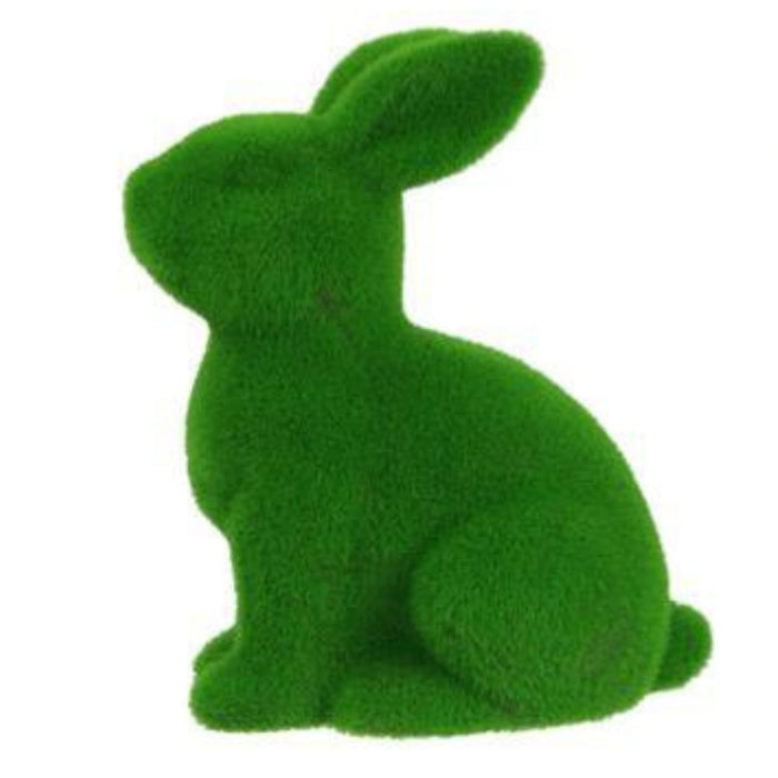 The 10H x 8.25L Flocked Sitting Rabbit, made from polystyrene/nylon, features a grass-textured surface with upright ears and a soft appearance. Available in purple, pink, black, green, orange, and turquoise (HE723199).