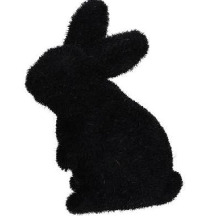 The 6Hx3.5L Flocked Standing Rabbit, made from polystyrene and nylon, is available in six assorted colors: purple, pink, orange, green, turquoise, and black. It features a silhouette of a sitting rabbit against a plain white background.