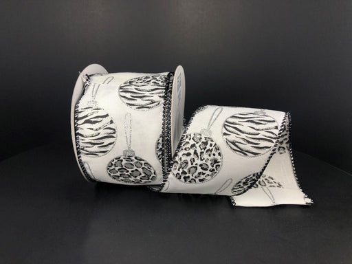 The White Satin/Silver Zebra-Cheetah Glitter Ornaments ribbon, measuring 2.5X10Y, features animal prints and Christmas ornaments, crafted from synthetic wired material, partially unrolled against a plain black background.