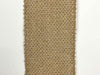 The Faux Nat Burlap 2.5" x 25 yd Ribbon (X501440-32B) features coarse, woven fabric with frayed edges, ideal for rustic crafts and creative projects. Displayed vertically on a white background.
