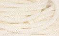 Close-up of the 8Mmx30Yd Faux Jute Flex Tubing in Cream, intricately coiled. The texture is soft and tightly woven, gently reflecting light. The cream polyester strands form interlocking patterns that add depth and detail.