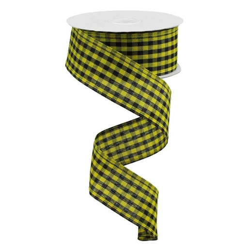 The 1.5 Yellow Black Gingham Check Ribbon RGA121157 is unwinding in a spiral pattern, showcasing its small checkered design in yellow and black, contrasting strikingly against the plain white background.
