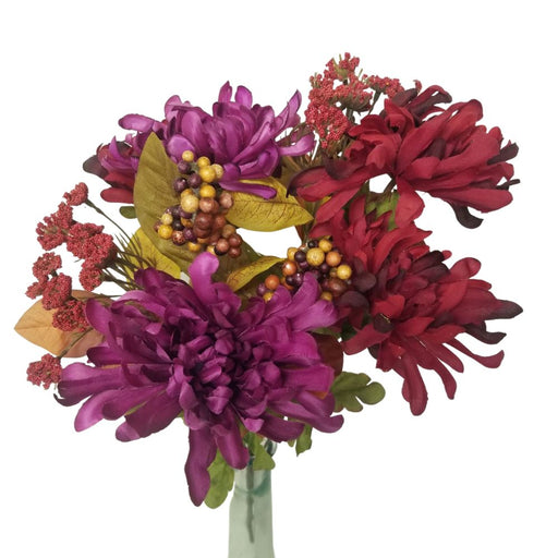 The 17.5 Burgundy and Purple Mum Q A L Berries Bush SBF1003-BPU features a vibrant bouquet of purple and burgundy chrysanthemums, adorned with red and multicolored berry clusters, complemented by green leaves against a white background.
