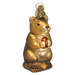 The Chipmunk Christmas 12145 Old World Christmas Ornament features a golden bear with an amber gem, reminiscent of a holiday heirloom. It stands upright with detailed features, shiny metallic finish, and has a loop for hanging as part of your festive décor.