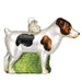 The Jack Russell Terrier 12218 Old World Christmas Dog Ornament is a glass ornament depicting a white-bodied Jack Russell with black and brown spots and a charming brown face, standing on a green glittery base, complete with a metal loop for easy hanging.