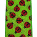 The 2.5 Green Linen Red Black Ladybug Ribbon Q917640-29 features a whimsical, vibrant green fabric with red ladybugs adorned with black spots. The ladybugs are evenly spaced, oriented in various directions, and the fabrics subtle texture is slightly visible.