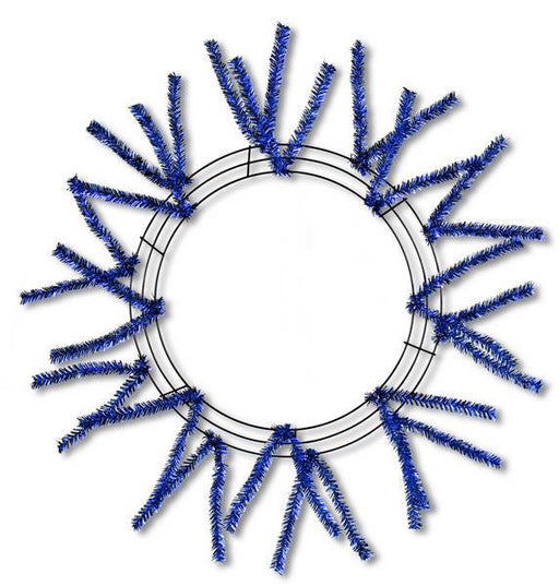 The 24" Pencil Wreath Metallic Royal Blue XX751125 features metallic royal blue pencil branches spaced evenly around the frame, forming a striking sunburst design against a white background.